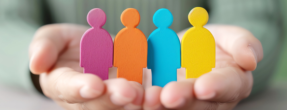 Eine Hand hält vier Holz-Figuren